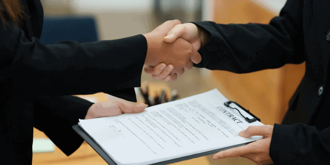 Business professionals shaking hands over a contract