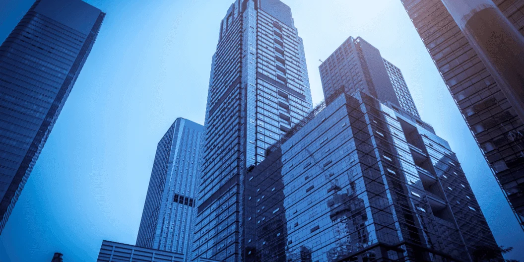 Glass office towers against a blue sky