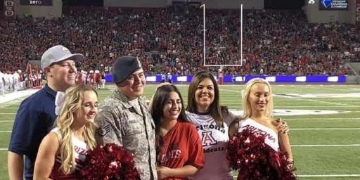 Service member honored with cheerleaders on the field at an Arizona Wildcats game