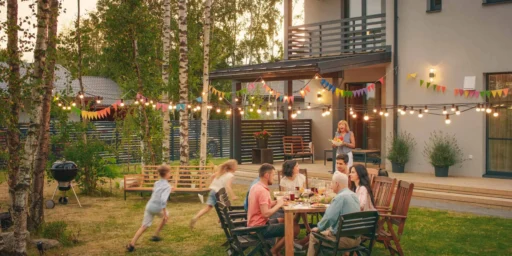 Family gathering at an outdoor backyard dinner under string lights