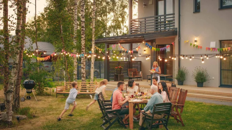 Family gathering at an outdoor backyard dinner under string lights