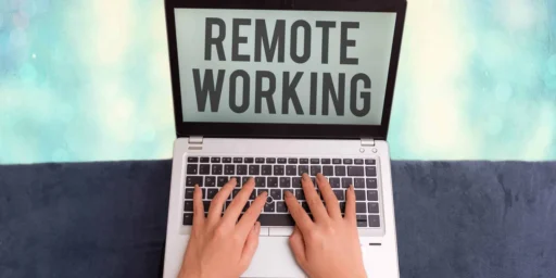 Hands typing on a laptop displaying the words Remote Working