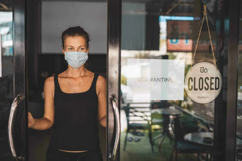 Store Owner in medical mask closed restaurant for quarantine