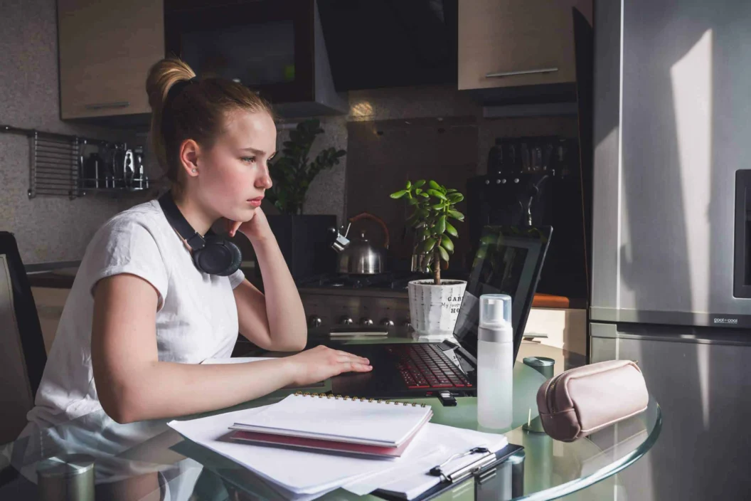 Coronavirus. Quarantine. Online training, remote work, office at home in the kitchen. Remote work, training, education. The girl is studying, working remotely. Coronavirus pandemic in the world.
