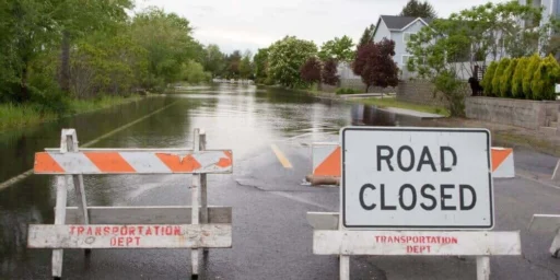 Road closed barricades in front of a flooded residential street