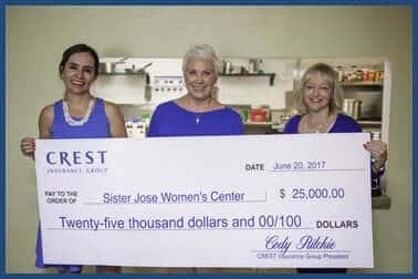 Three women holding a $25,000 Crest Insurance Group check made out to Sister Jose Women's Center