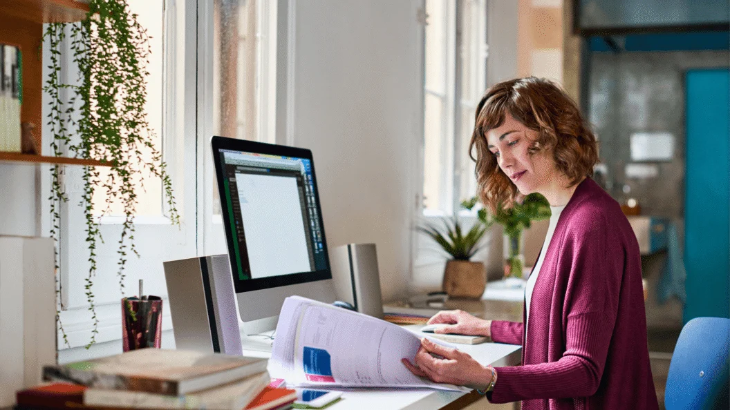 Woman reviewing documents at a home office desk