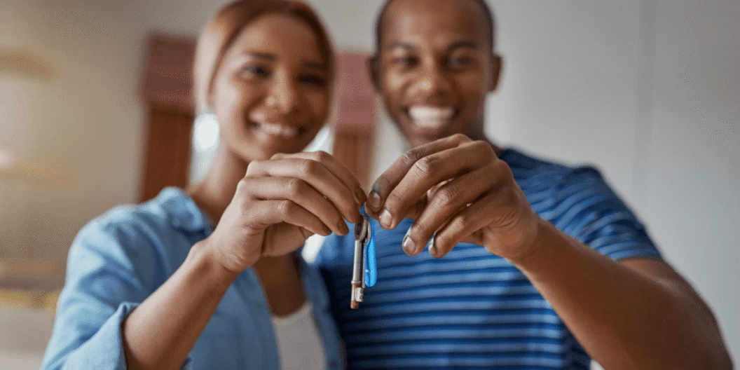 Two people holding the keys to their new home