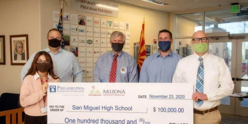 Crest Insurance and Philadelphia Insurance presenting a $100,000 check to San Miguel High School