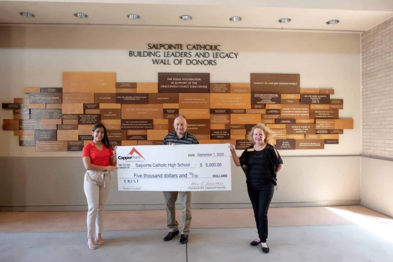 Crest Insurance and CopperPoint presenting a $5,000 check at Salpointe Catholic High School