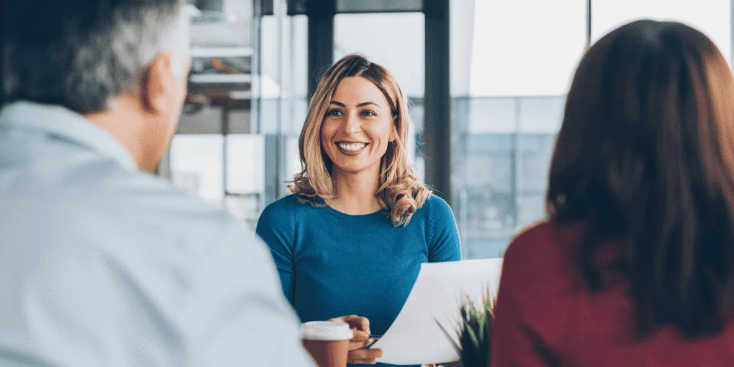 Woman smiling during meeting with two other people