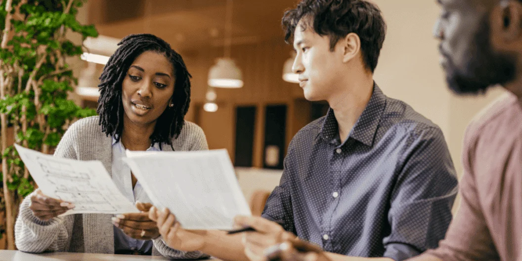 Colleagues reviewing insurance documents together at a table