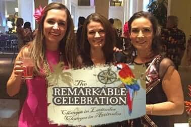Three women holding a Remarkable Celebration sign