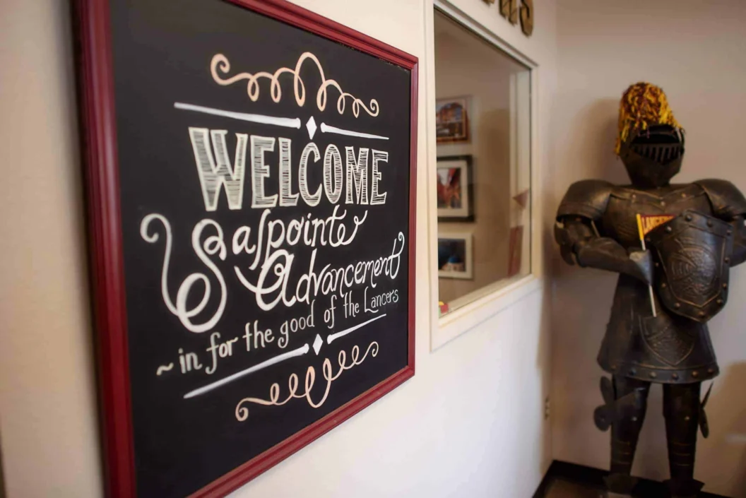 Salpointe Catholic High School welcome sign beside a suit of armor