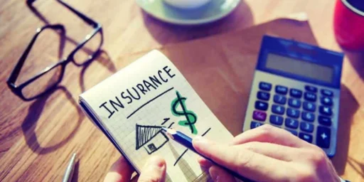 Person calculating insurance costs with a notepad and calculator