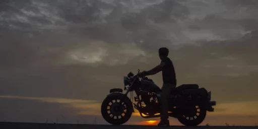 Motorcyclist silhouetted against a sunset