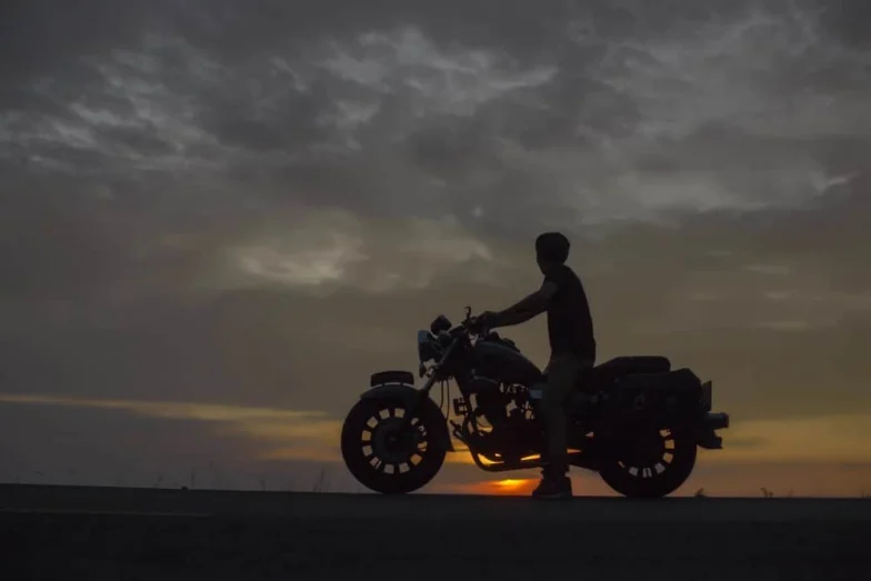 Motorcyclist silhouetted against a sunset