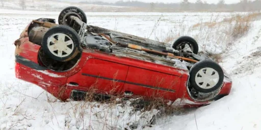 Red car overturned in a snowy field